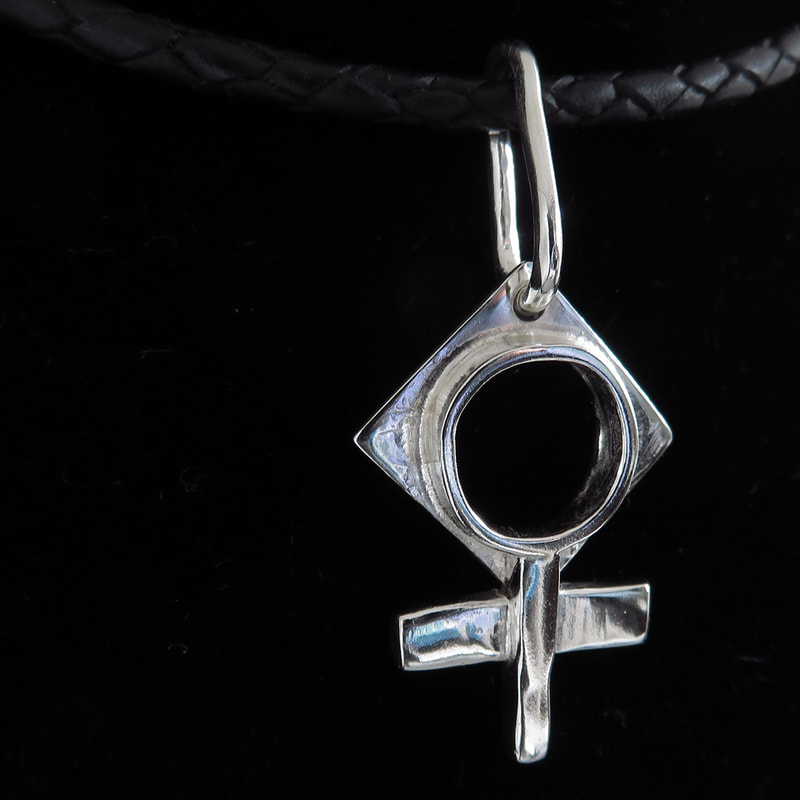 Sterling silver pendant handmade symbol of 'woman' suspended from braided leather on black backgroundPicture
